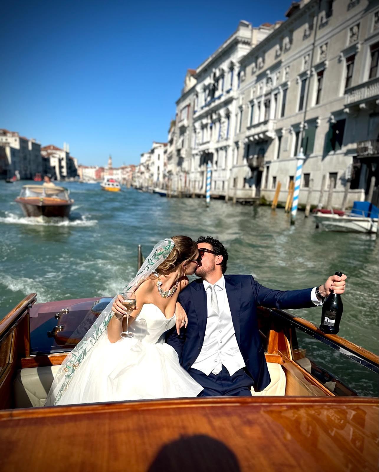 Bride and groom kissing on a boat in Venice